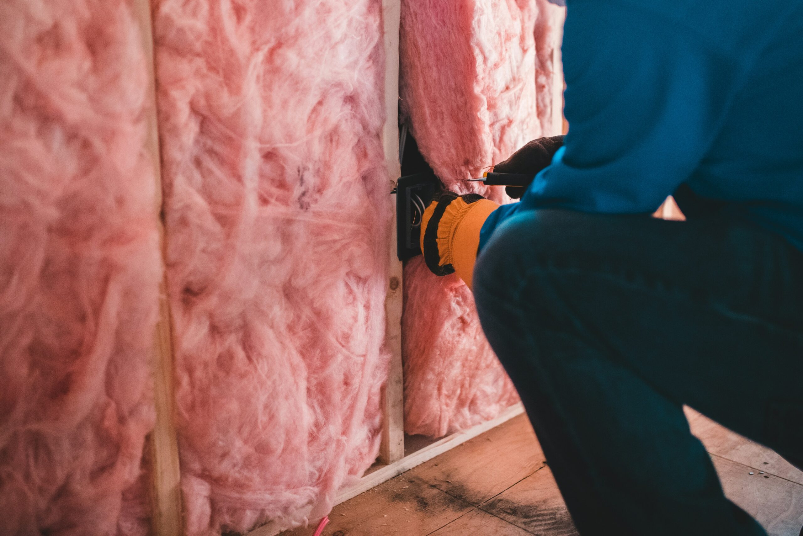man installing insulation in a wall